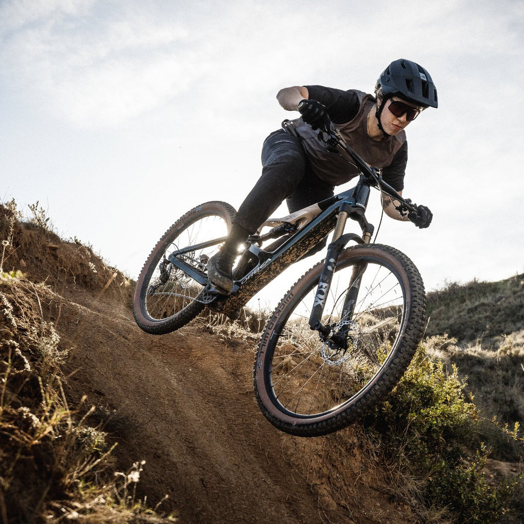 Mann fährt auf einem Light E MTB einen Trail runter.
